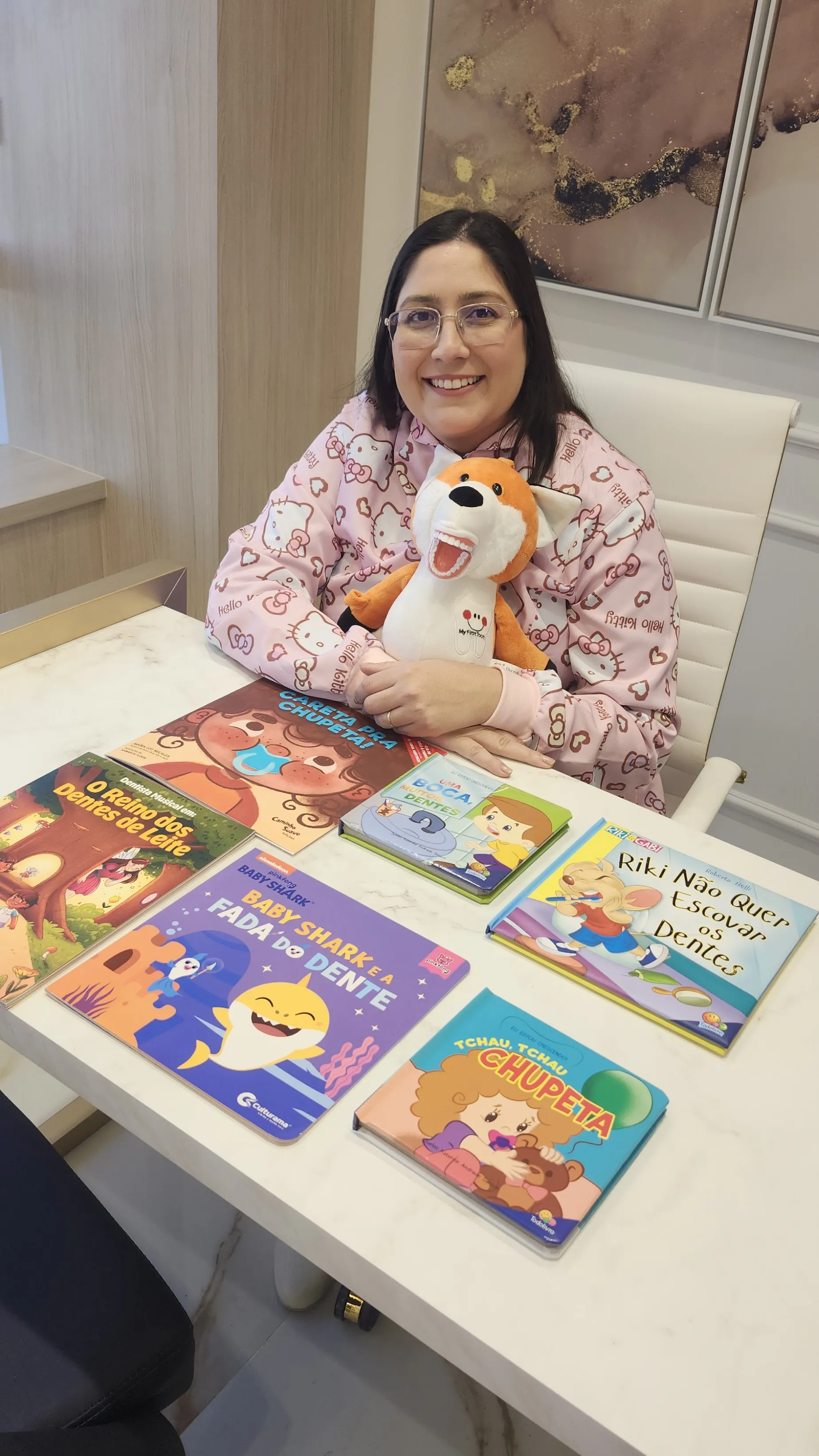 Dra. Mara com livros infantis e pelúcia raposa