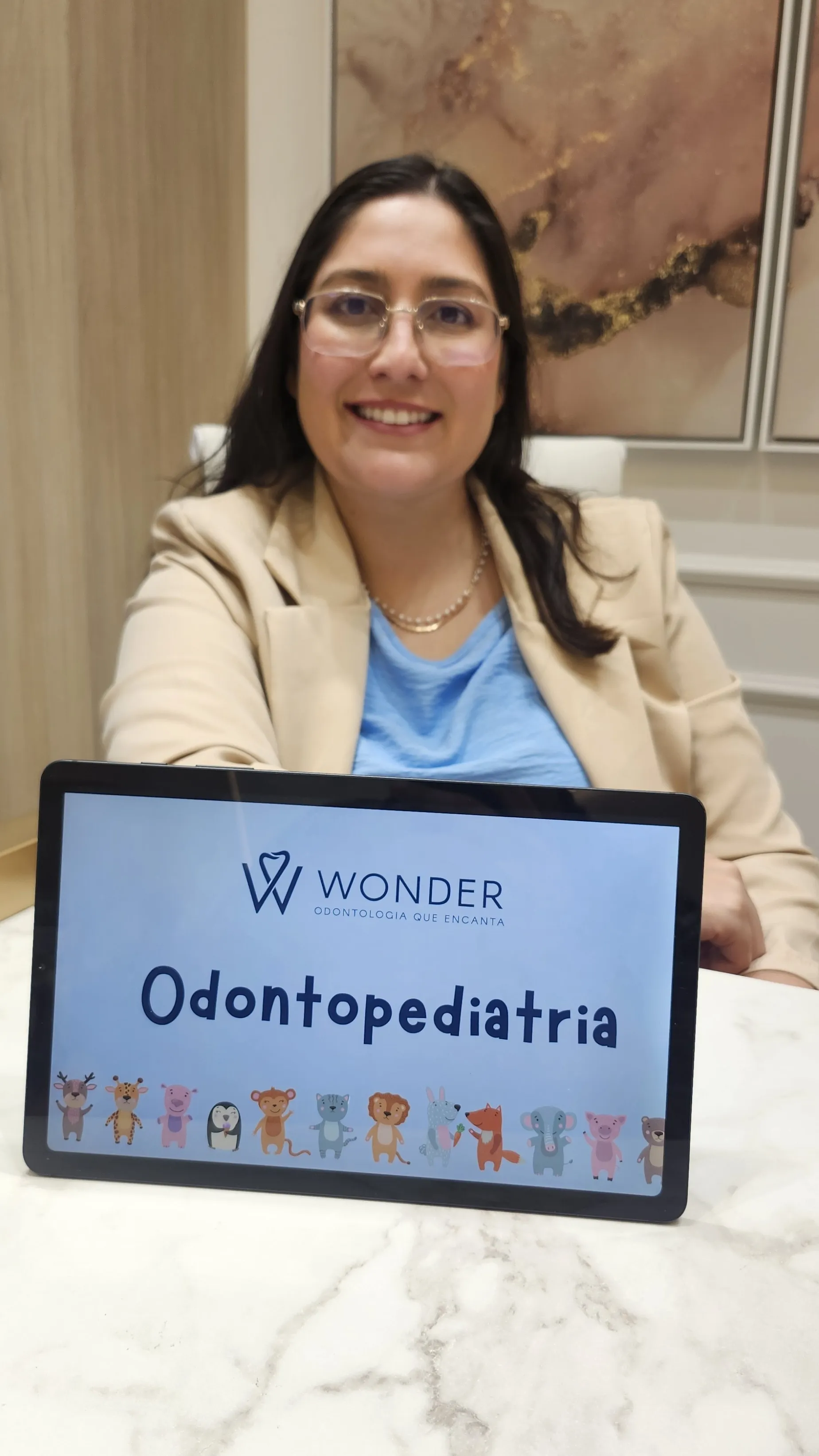 Dra. Mara com tablet Wonder Odontopediatria